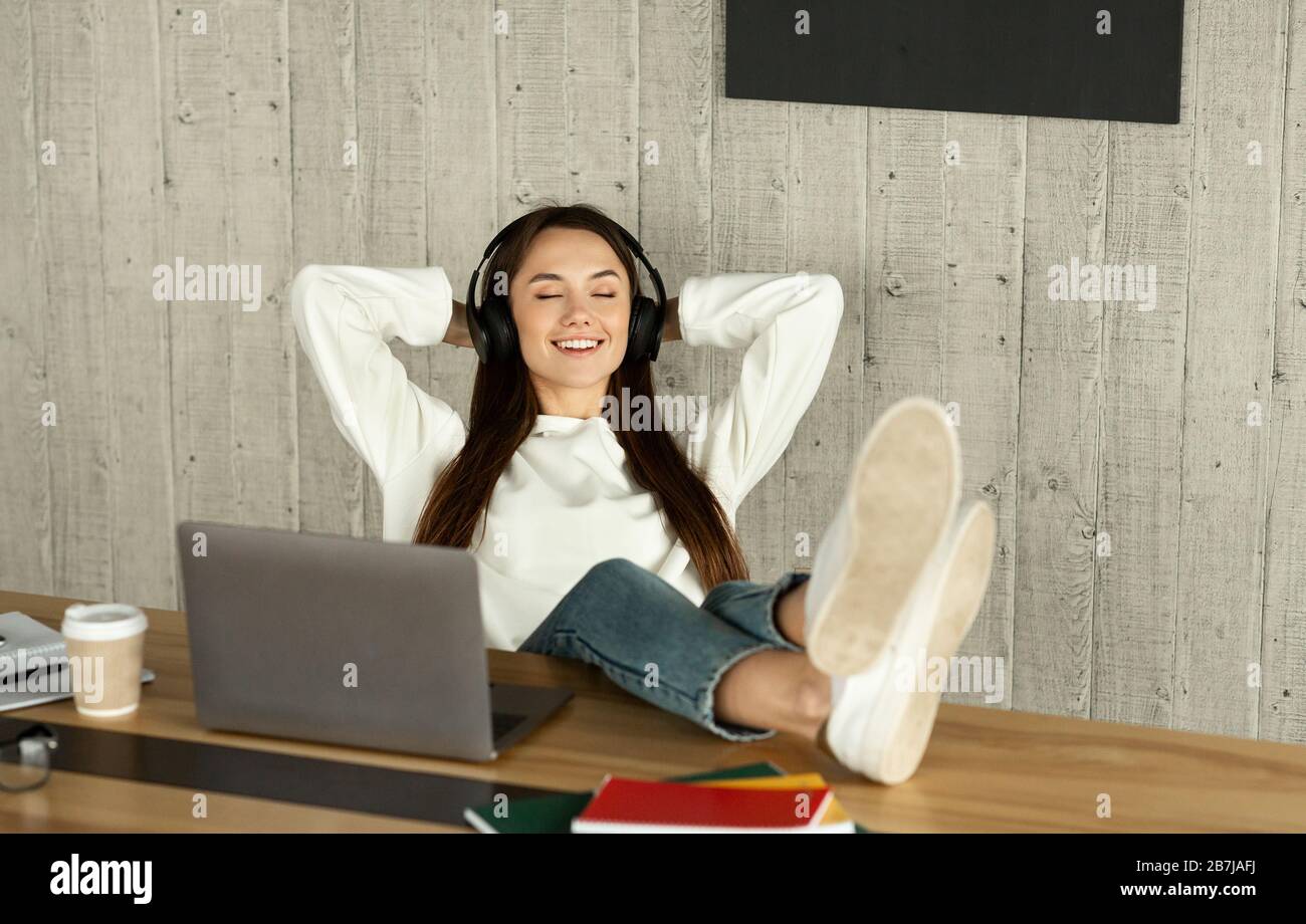 La jeune fille Freelance a mis ses pieds sur la table Banque D'Images