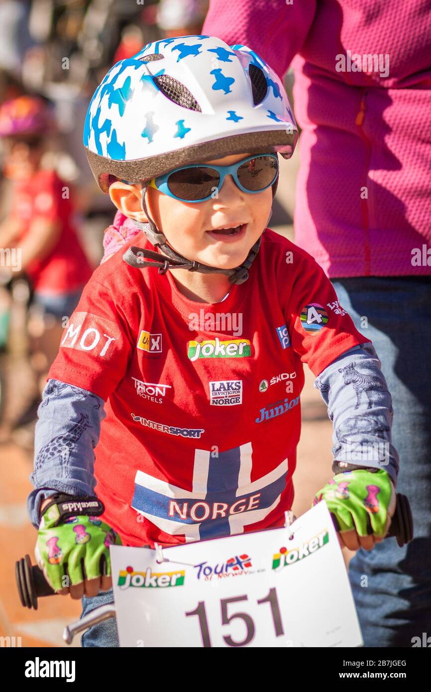 Petit enfant sur le vélo souriant sur la ligne de départ de la course de  vélo. Lunettes de soleil et casque. T-shirt avec drapeau norvégien Photo  Stock - Alamy