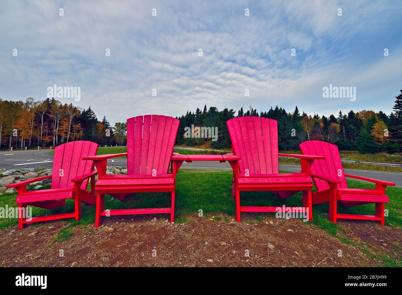 Quatre chaises rouges, disposées sur une petite colline, pour permettre à une famille de profiter de la vue sur la baie de Fundy, dans le parc national Fundy, Nouveau-Brunswick, Canada. Banque D'Images