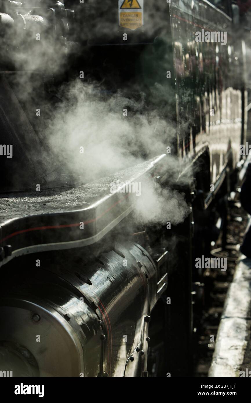 Un ingénieur ajuste son bouchon à côté d'un train à vapeur sur le chemin de fer East Lancashire à Ramsbottom, Lancashire, Angleterre Banque D'Images