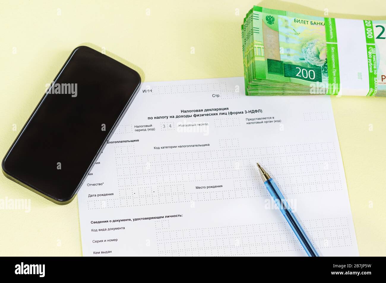 Documenter en russe la « Déclaration fiscale sur l'impôt sur le revenu des  particuliers », le PEN, le smartphone et l'argent pour le paiement de l' impôt. Temps de déclaration des revenus Photo