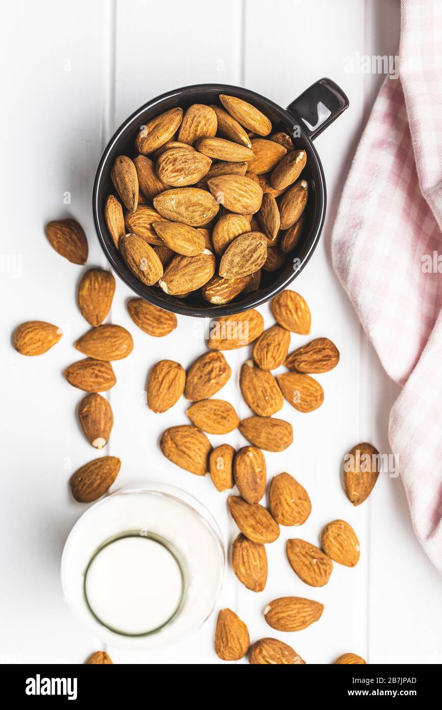 Noix d'amandes et lait d'amandes sur table blanche. Banque D'Images