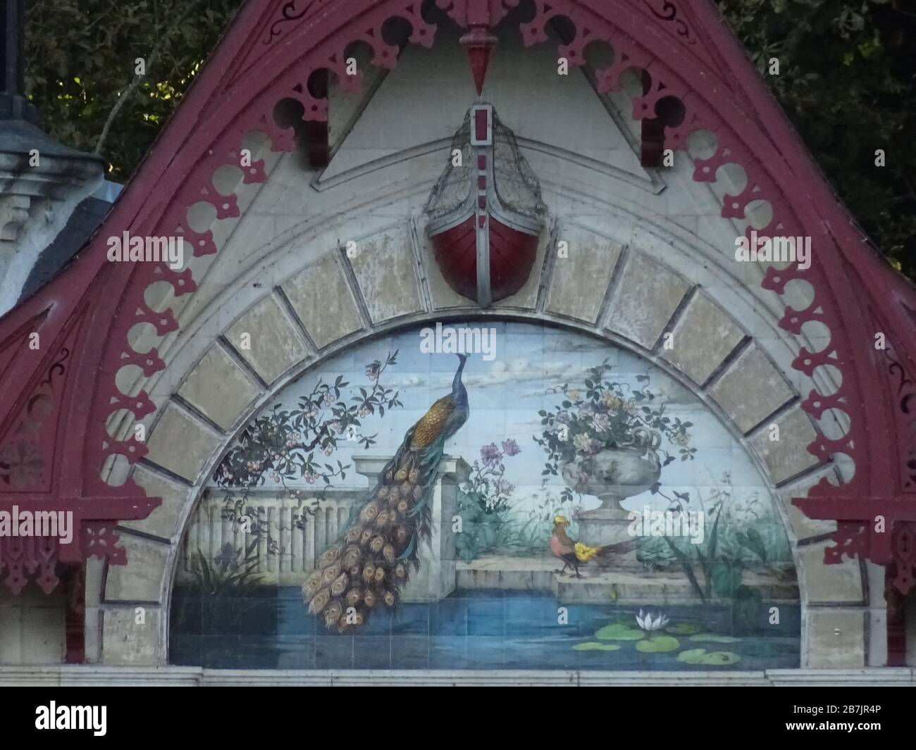 belle peinture d'un paon dans le parc sur une ancienne maison de bateau avec la tonte de bois rouge près de la rivière Banque D'Images