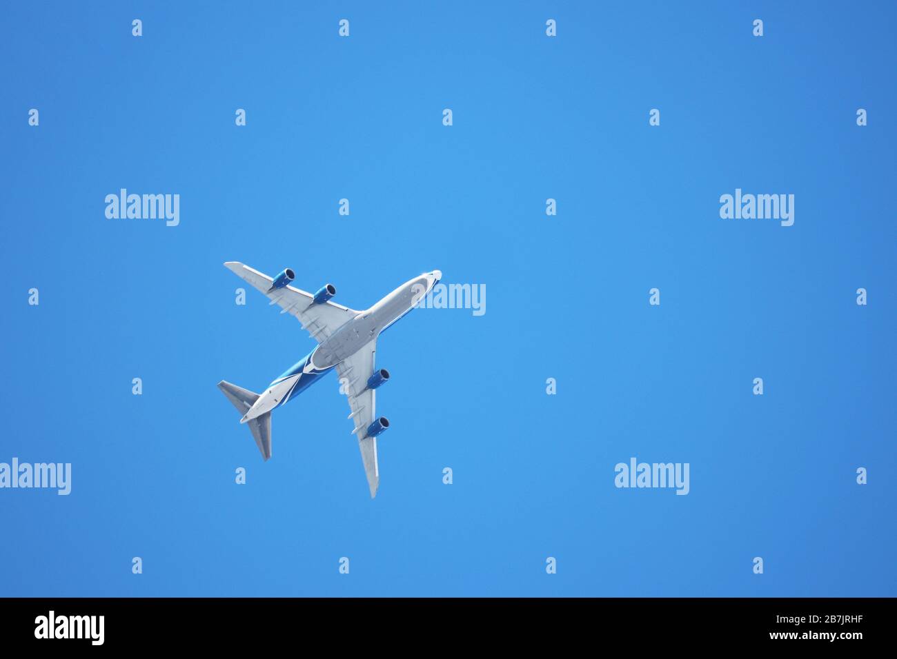 Avion volant dans le ciel bleu clair, vue de dessous. Avion commercial à quatre moteurs pendant le décollage Banque D'Images