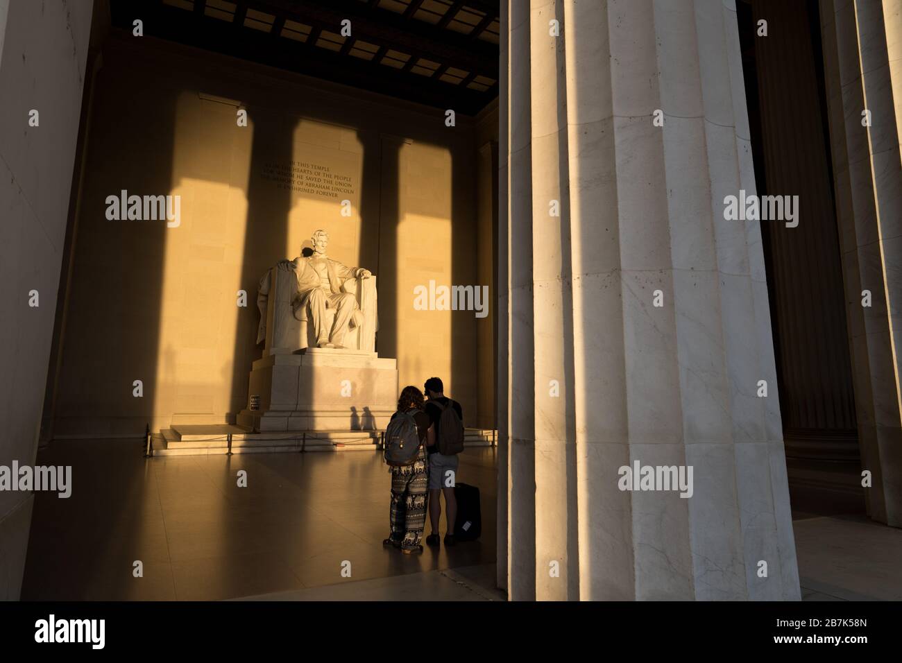 WASHINGTON DC, USA - La grande statue à l'intérieur de la chambre principale du mémorial Lincoln attraper tôt le matin au lever du soleil d'or au cours de l'automne (automne) equinox. Le Lincoln Memorial est situé sur l'extrémité ouest de la Reflecting Pool et fait face directement à l'Est. La statue est profond au sein de la chambre et est normalement bien hors de portée de la lumière du soleil directement. Banque D'Images