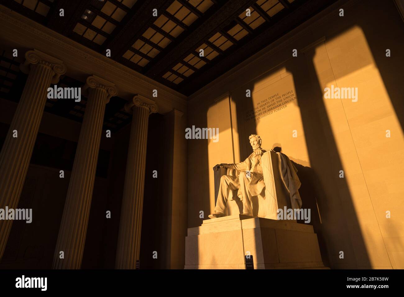 WASHINGTON DC, USA - La grande statue à l'intérieur de la chambre principale du mémorial Lincoln attraper tôt le matin au lever du soleil d'or au cours de l'automne (automne) equinox. Le Lincoln Memorial est situé sur l'extrémité ouest de la Reflecting Pool et fait face directement à l'Est. La statue est profond au sein de la chambre et est normalement bien hors de portée de la lumière du soleil directement. Banque D'Images