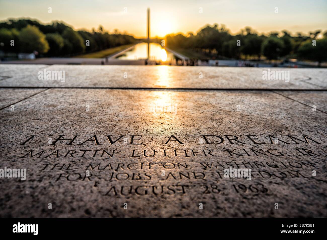 WASHINGTON DC, États-Unis — le soleil se lève derrière le Washington Monument, vu de l'endroit où le Dr Martin Luther King Jr a prononcé son célèbre discours « J'ai un rêve » sur les marches du Lincoln Memorial à Washington DC. Une plaque commémorant la tache est gravée dans les marches de marbre. Banque D'Images