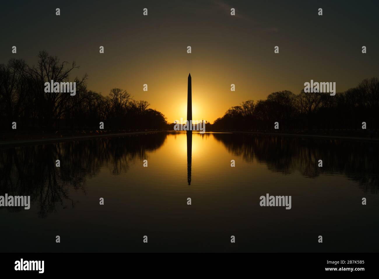 Washington Monument Reflecting Pool Sunrise Washington DC // WASHINGTON DC — le Washington Monument se reflète dans les eaux calmes du Reflecting Pool au lever du soleil. La lumière matinale baigne le National Mall d'une lueur chaude, mettant en valeur l'obélisque emblématique et créant une scène sereine et pittoresque. Le Washington Monument, l'un des monuments les plus reconnaissables aux États-Unis, est un hommage au premier président du pays, George Washington. Banque D'Images