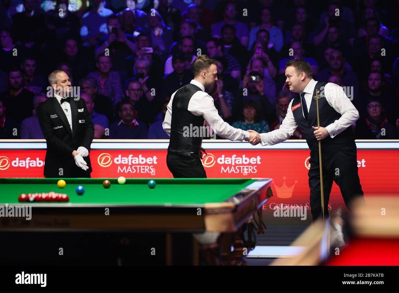 Judd Trump d'Angleterre, au milieu, se réveille avec Shaun Murphy d'Angleterre, à droite, lors du premier match de 2020 Masters à Londres, le Royaume-Uni Banque D'Images