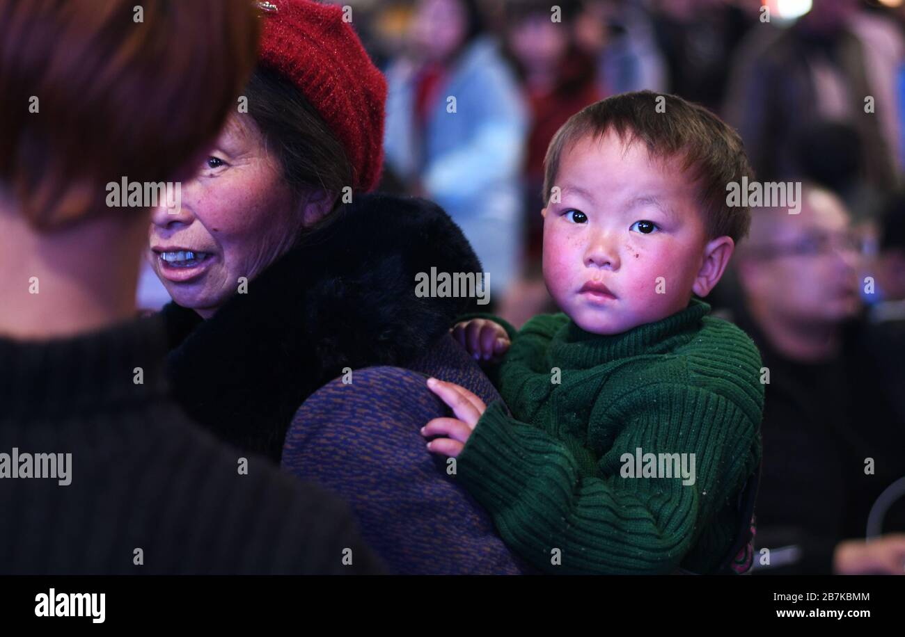 Les mères transportant leurs enfants sur leur dos et leurs bagages, en attendant le train en direction de la maison situé à 3000 km de Sichuan, qui les prendra 36 Banque D'Images