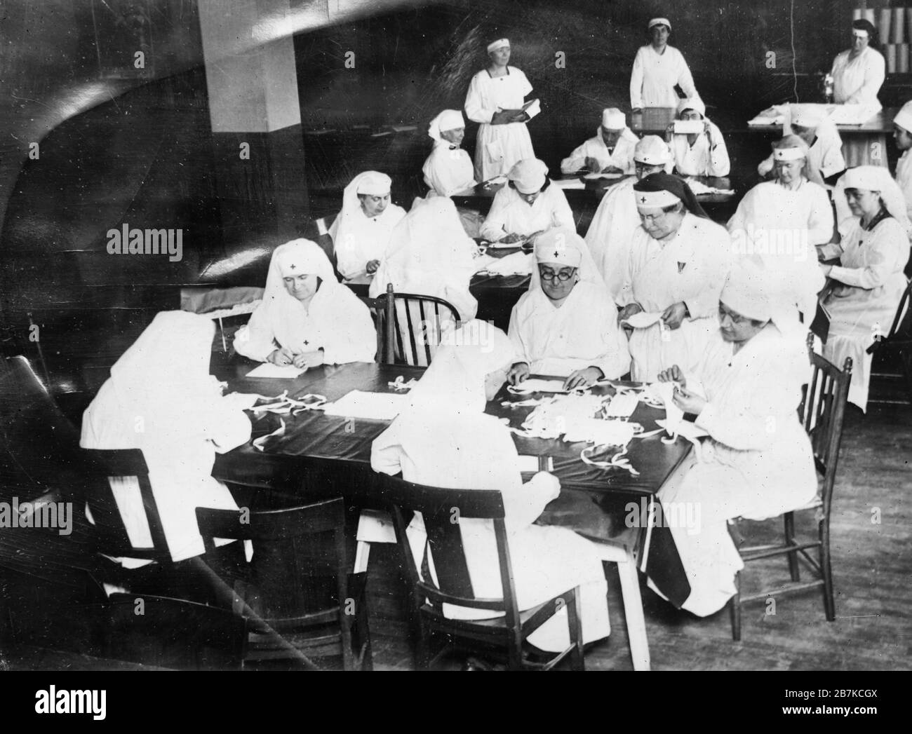 Croix-Rouge femmes au chapitre du comté de New York à la salle de travail à 82ème rue et à l'avenue Amsterdam, en se tournant vers les fournitures médicales et l'équipement hospitalier à utiliser par le département de santé de la ville dans sa guerre contre la grippe. L'organisation des unités du chapitre était donc complète, que le premier appel à fournitures a permis à la Croix-Rouge de mobiliser ses travailleurs immédiatement et que les sept zones de santé désignées par le Département de la santé ont été constamment renforcées avec les nécessités. Janvier 1920 Banque D'Images