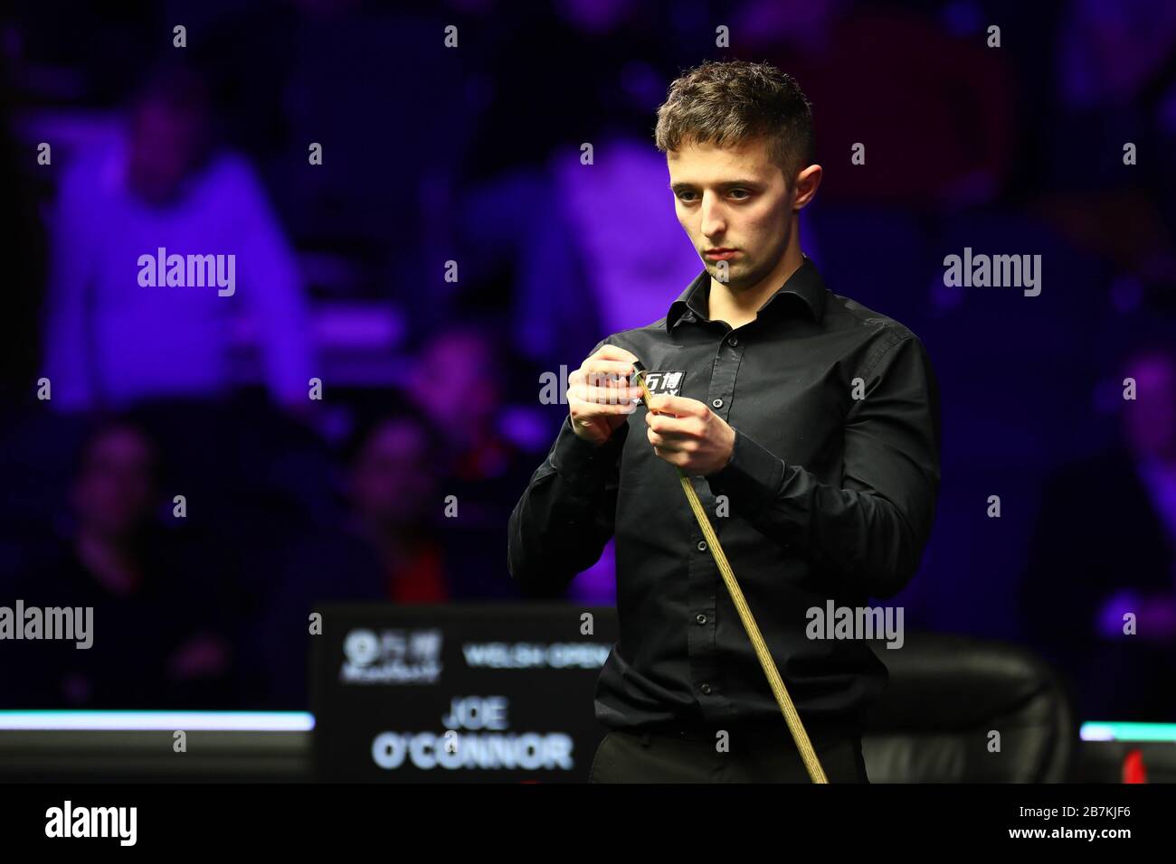 Joe O'Connor, joueur de snooker anglais, craie son signal tout en considérant un tir contre John Higgins, joueur professionnel écossais de snooker, lors du premier rou Banque D'Images