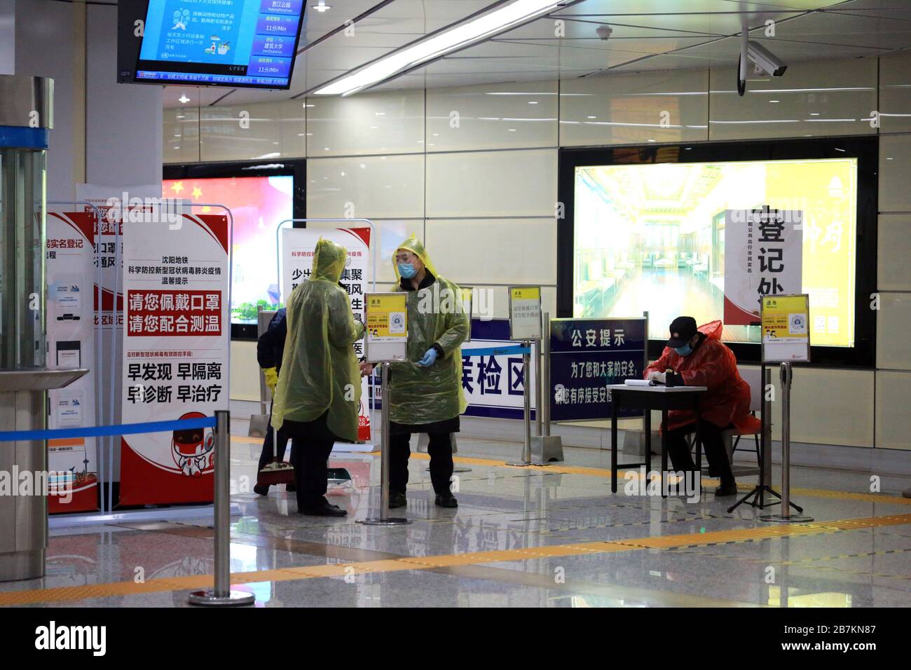 Un personnel, à droite, regarde une personne scannant le code QR d'un programme de rapport de santé dans un métro dans la ville de Shenyang, province de Liaoning dans le nord-est de la Chine, le 14 février Banque D'Images