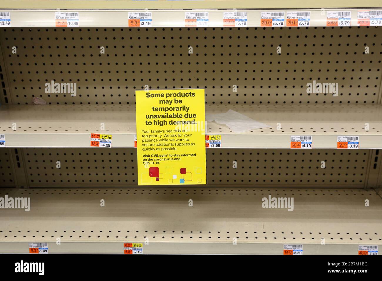 Un signe d'avertissement de non-disponibilité du produit se trouve sur une étagère vidée d'alcool isopropylique et de bandages dans un magasin de médicaments de la chaîne de New York, le 16 mars 2020 Banque D'Images