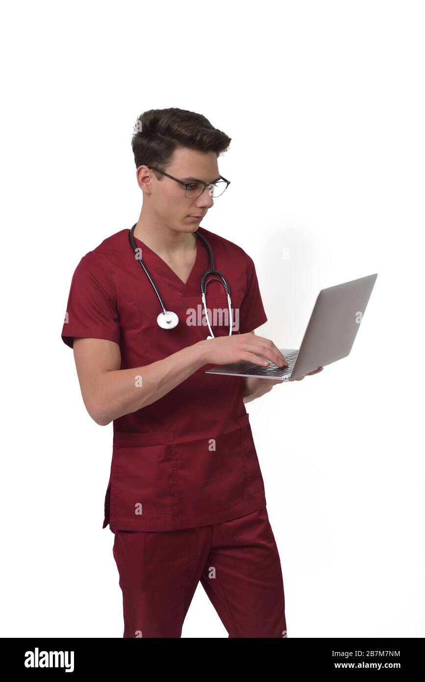 Jeune médecin mâle avec stéthoscope sur le cou travaillant sur ordinateur portable, isolé sur blanc Banque D'Images