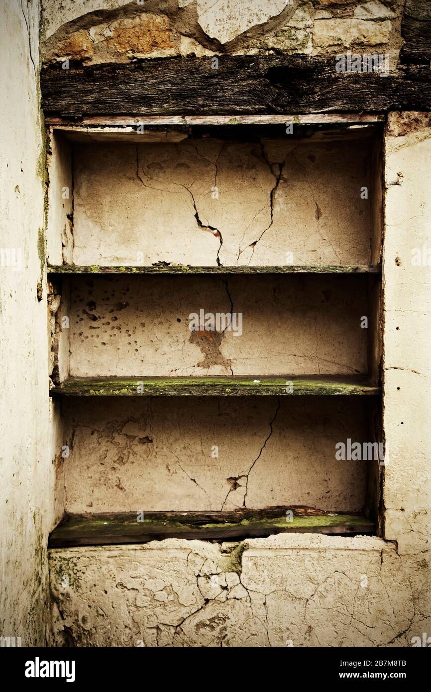 Etagères en bois fixées au mur dans un bâtiment abandonné et délabrés. Banque D'Images