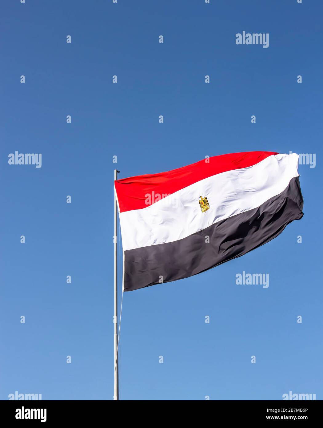 Drapeau national de l'Egypte qui vole haut contre le ciel bleu Banque D'Images