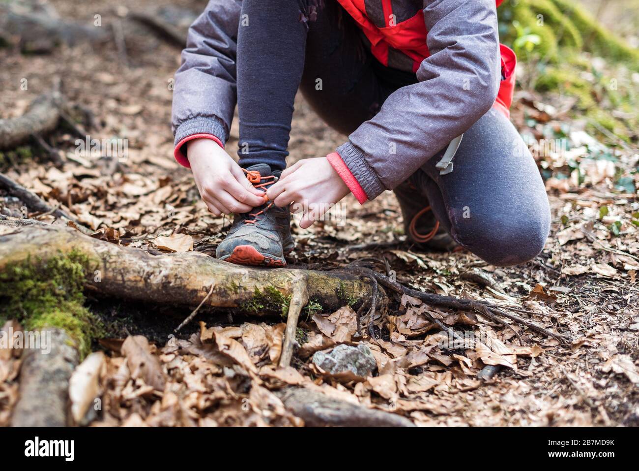 Portrait d'une fille sur la randonnée en forêt voyage nouant les lacets de chaussures. Portrait d'hiver de fille sur la randonnée familiale et moulin à eau, la famille active, les parents et les enfants Mo Banque D'Images