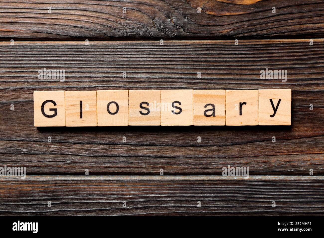 Mot Glossaire écrit sur le bloc de bois. Glossaire texte sur table en bois pour votre dessing, concept de vue de dessus. Banque D'Images