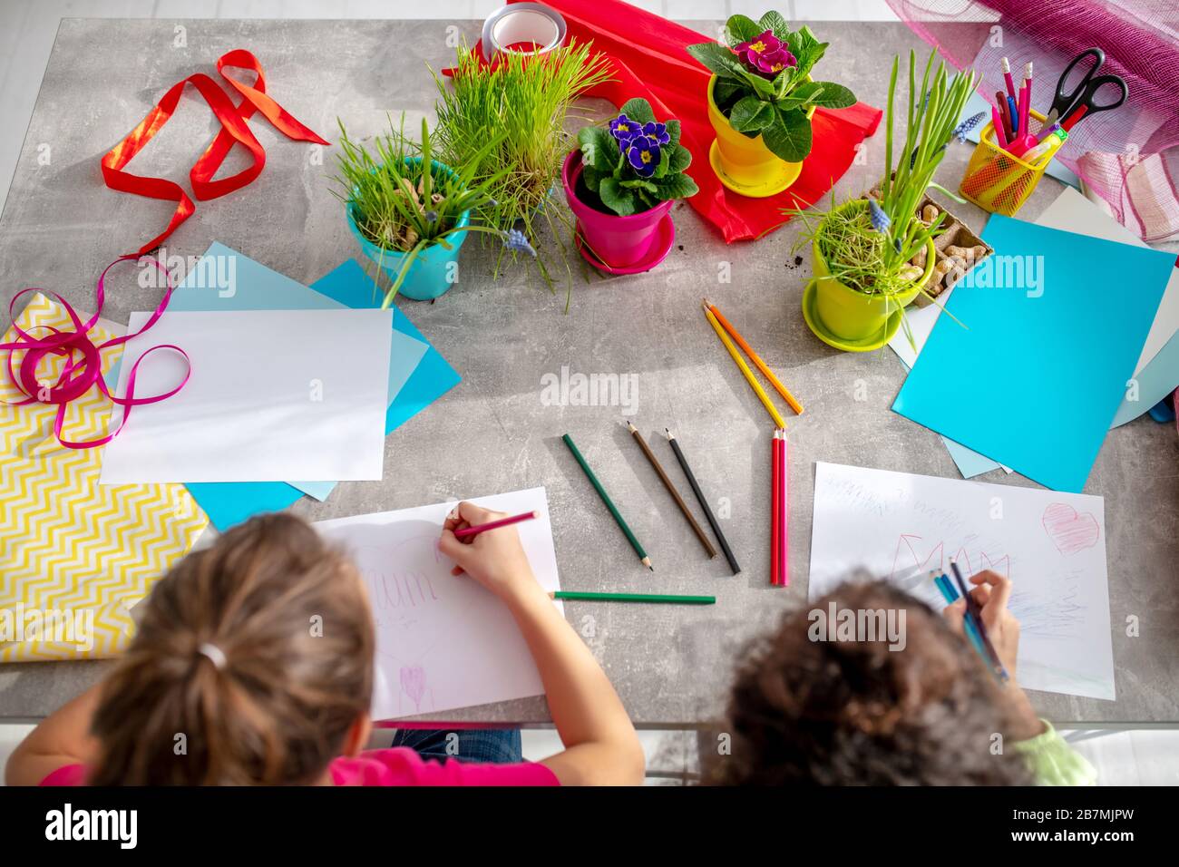 Deux filles peignant des photos de couleur à la table. Banque D'Images