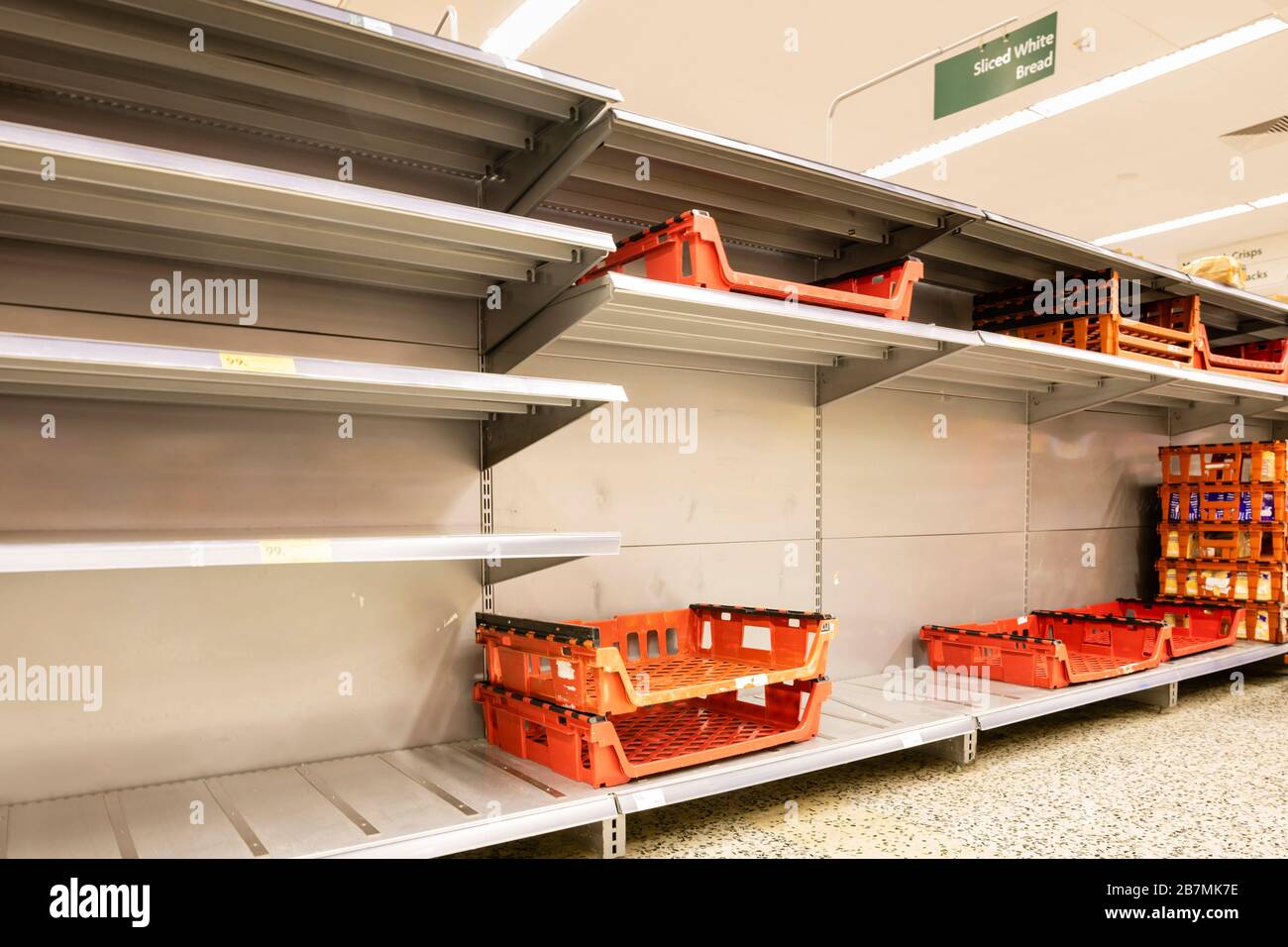 Vider les étagères dans un supermarché britannique où les acheteurs ont paniqué acheter du pain en raison de la pandémie de coronavirus. Banque D'Images