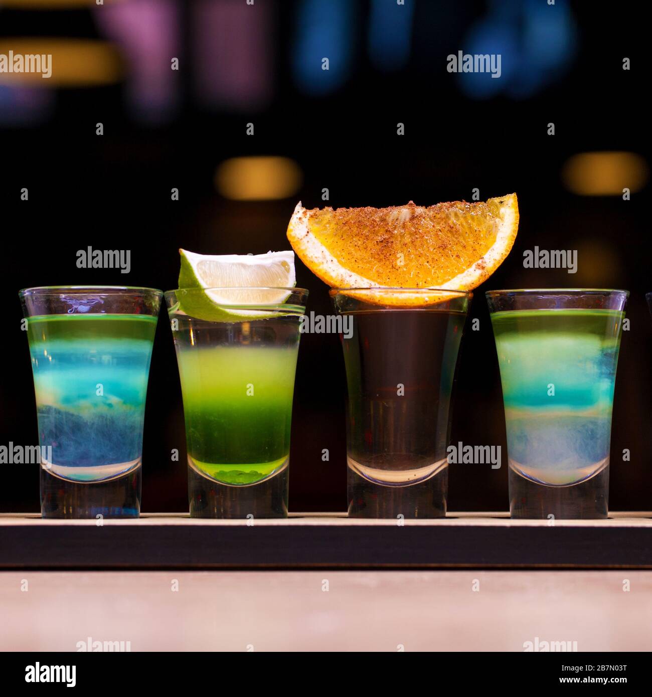 Quatre prises de vue avec cocktails alcoolisés sur une planche en bois. Cocktails au bar assortis Banque D'Images