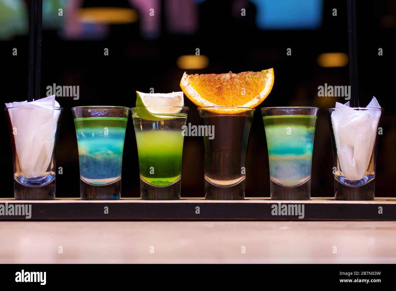 Quatre prises de vue avec cocktails alcoolisés sur une planche en bois. Cocktails au bar assortis Banque D'Images