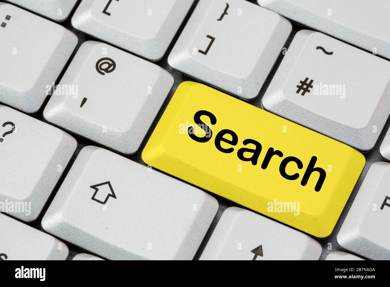 Un clavier avec recherche écrite en lettres noires sur une touche de saisie jaune. Concept de moteur de recherche. Angleterre, Royaume-Uni, Grande-Bretagne Banque D'Images
