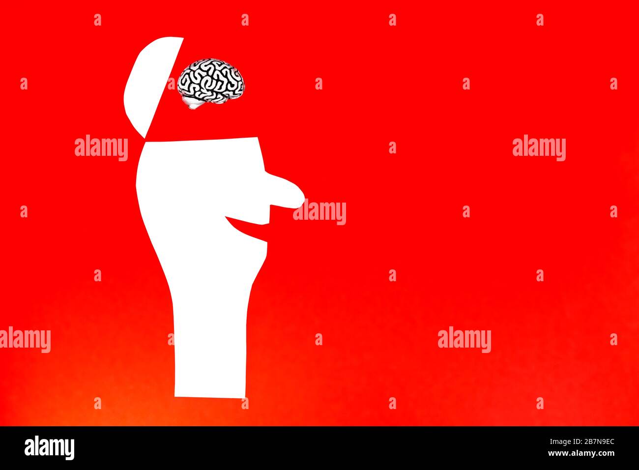 Petit modèle de cerveau humain inséré à l'intérieur d'une tête ouverte d'un homme heureux coupé de papier sur un fond rouge. Copier l'espace, le concept de bonheur. Banque D'Images