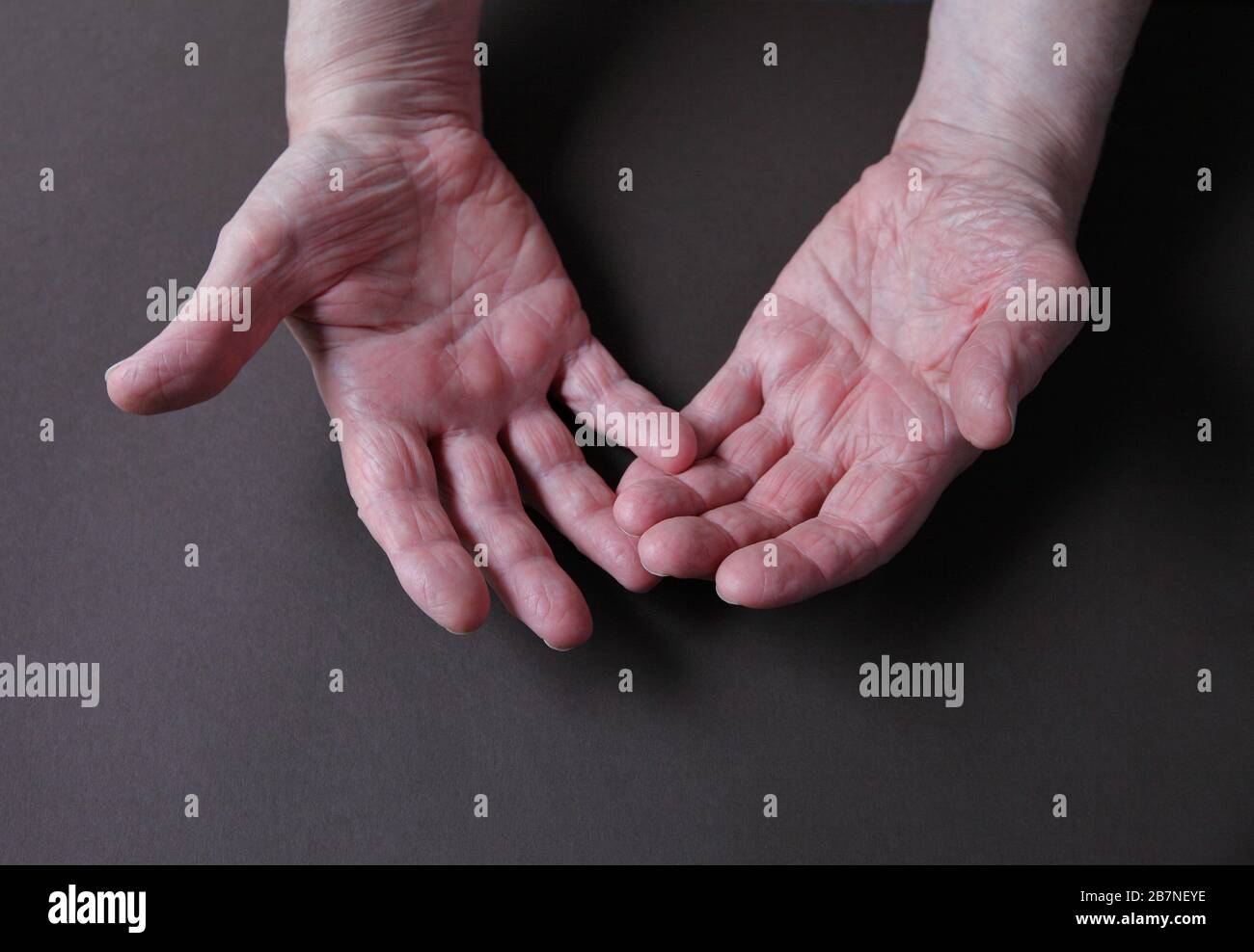 L'homme plus âgé a la main sur un fond sombre avec un espace de copie Banque D'Images