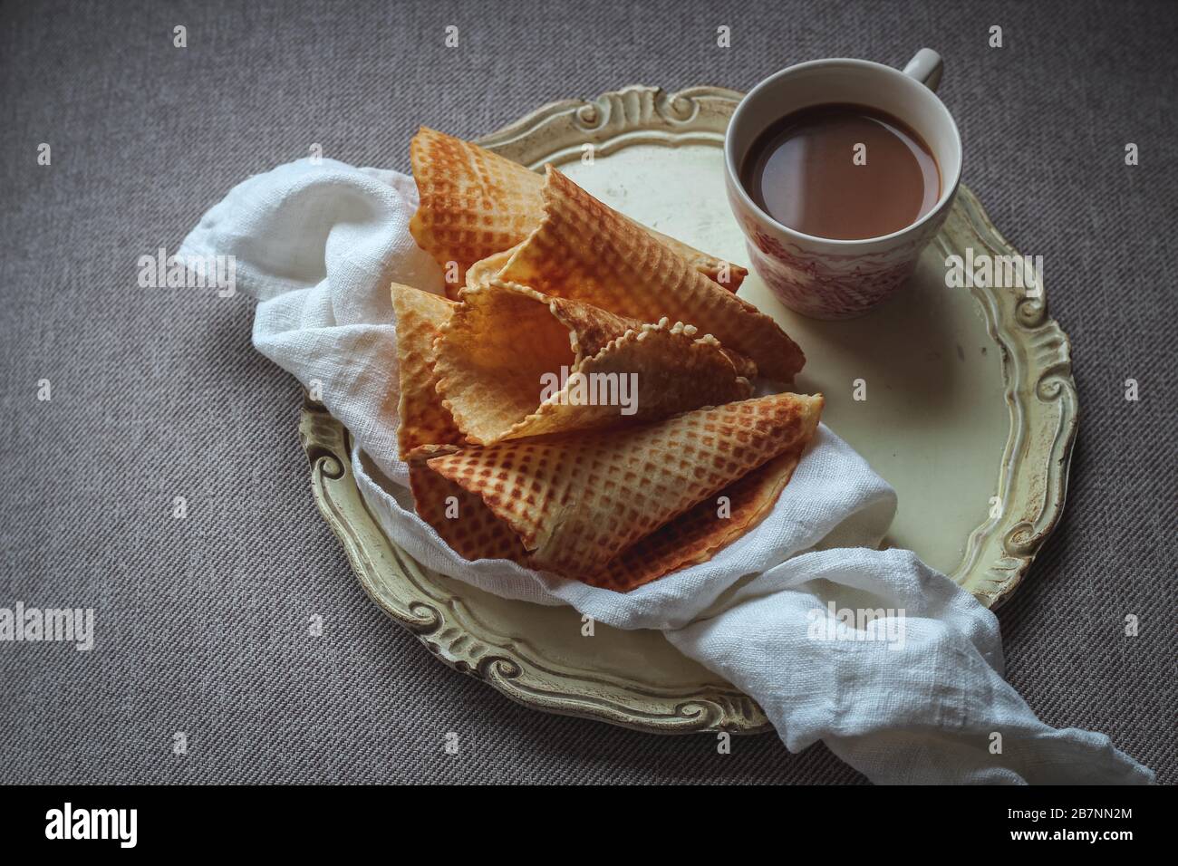 Gaufres fines maison et une tasse de café avec du lait sur un plateau pour un brunch du week-end Banque D'Images