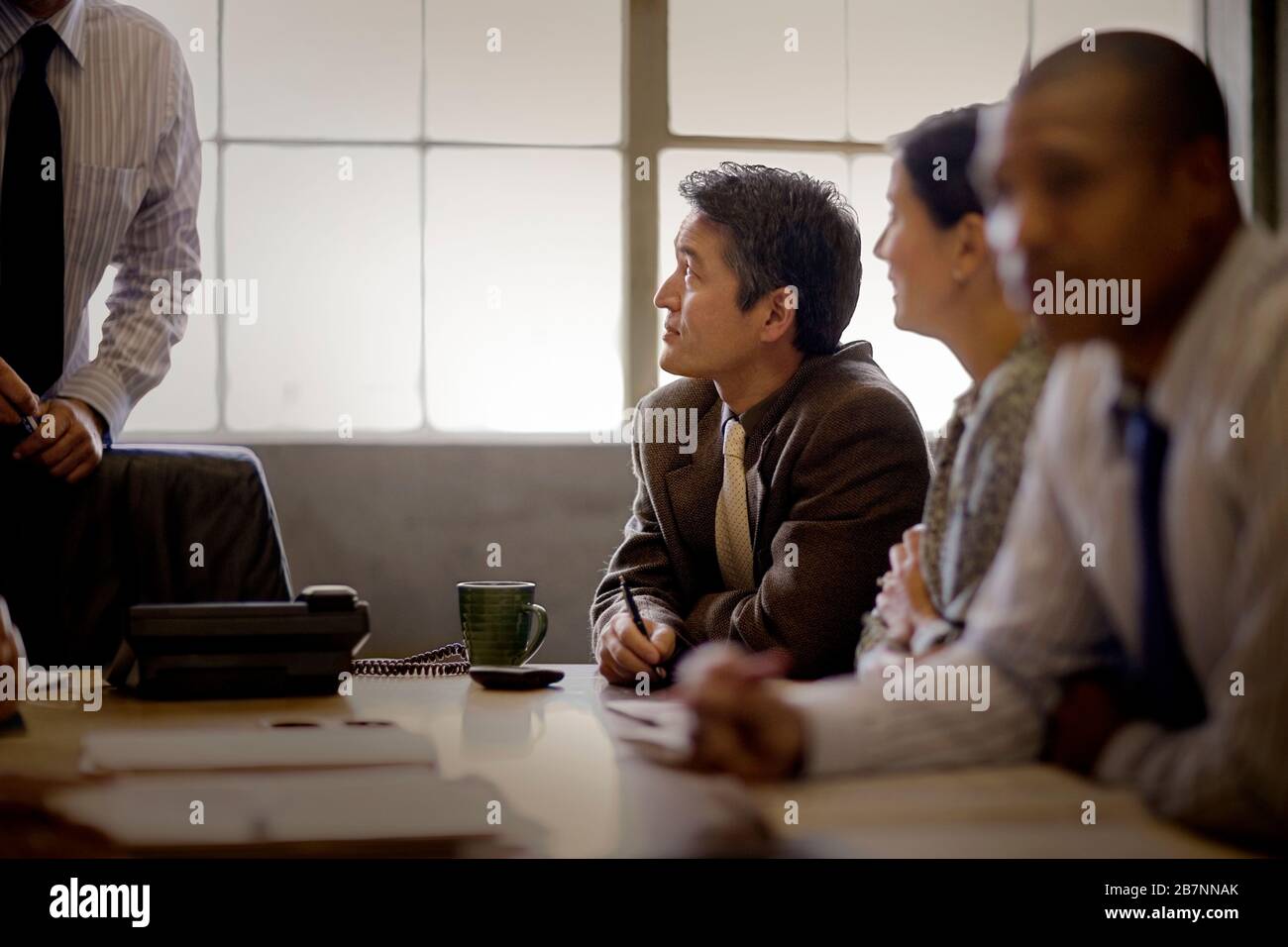 Homme d'affaires adulte mûr assis avec des collègues dans une salle de conférence. Banque D'Images