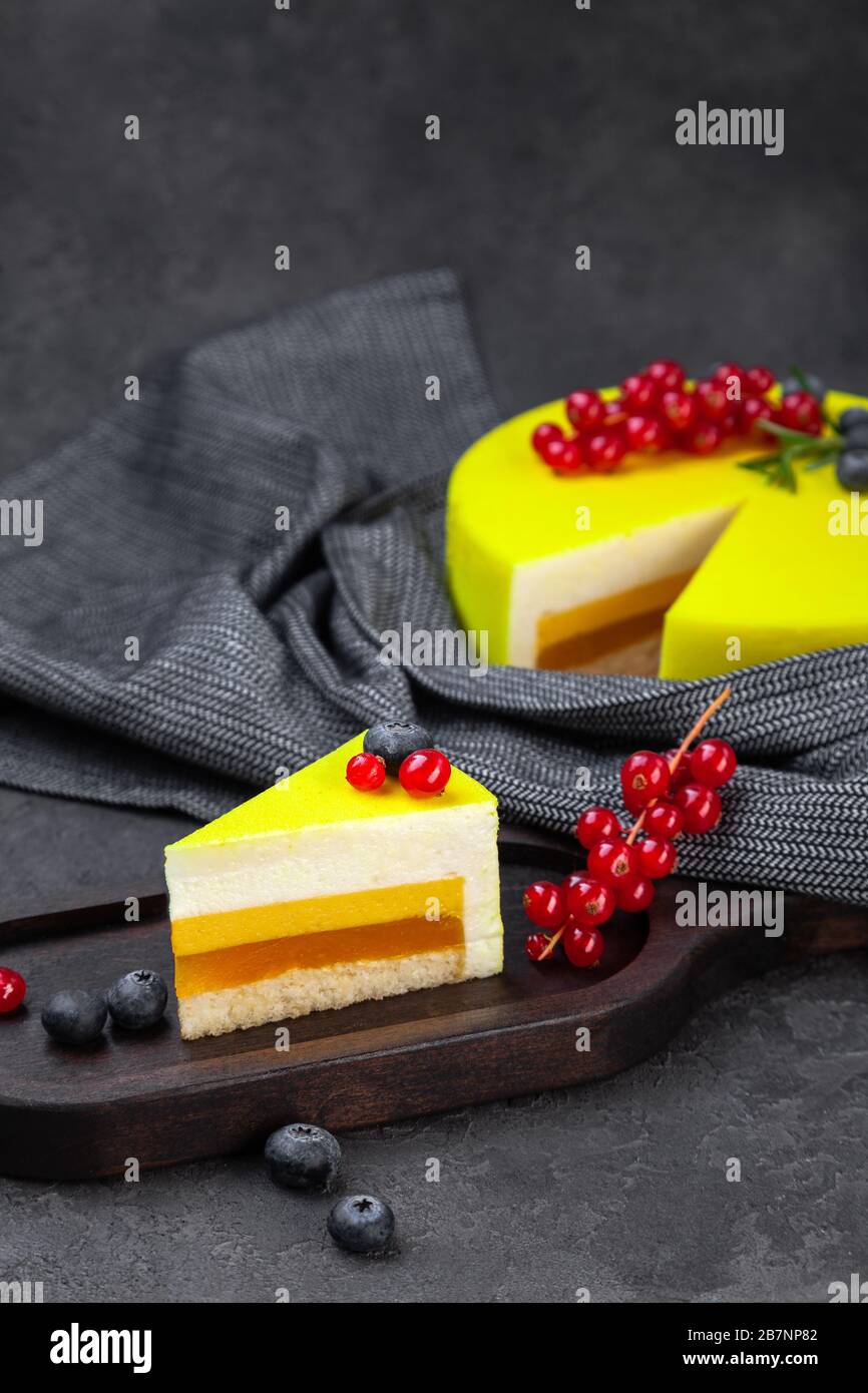 Gateau Jaune A La Couche De Citron Et Piece Sur Plaque En Bois Et Cassis Rouge Decore De Bleuets Sur Fond Sombre Espace De Copie Place Pour Le Texte Ve Photo Stock