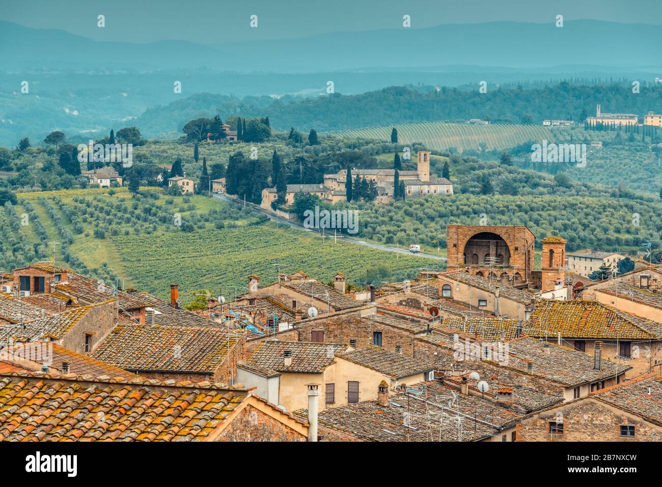 Toits de San Gimignano, campagne toscane avec collines ondulantes et Santa Maria Assunta a Monte Oliveto Minore de Parco della Rocca, San Gimignano. Banque D'Images