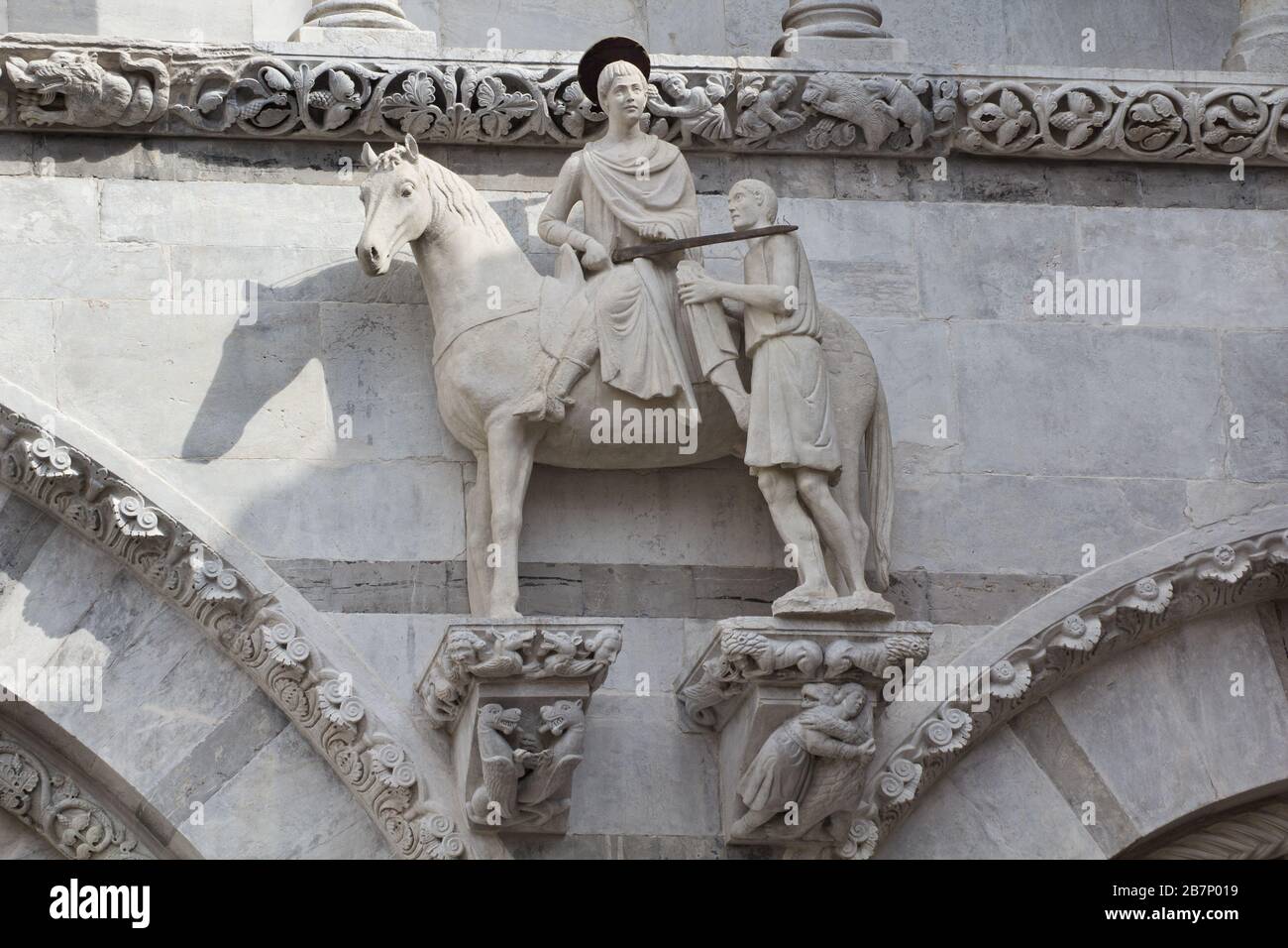 La statue médiévale de Saint Martin et le mendiant sur la façade de la cathédrale de Lucques, Toscane, Italie Banque D'Images
