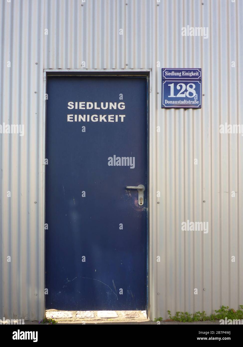 Wien, Vienne: entrée de la maison dans le domaine immobilier "Siedlung EINIGKEIT" derrière le mur insonorisé en fer ondulé, en 22. Donaustadt, Wien, Autriche Banque D'Images