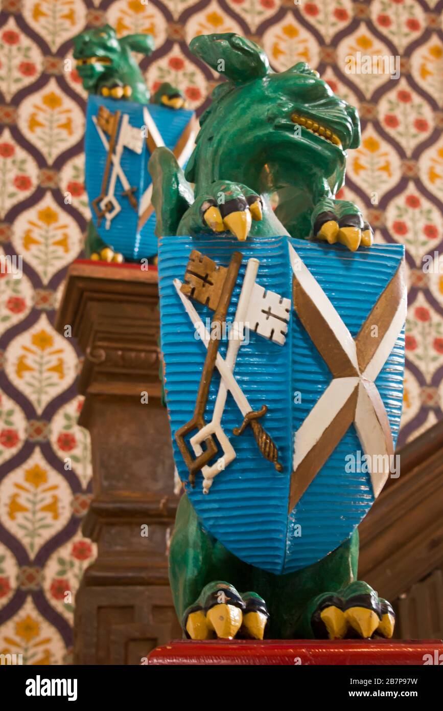 Un dragon sculpté tenant les armoiries sur l'escalier principal de la Bishops House I The Bishops Palace à Wells, Somerset, Angleterre, Royaume-Uni Banque D'Images