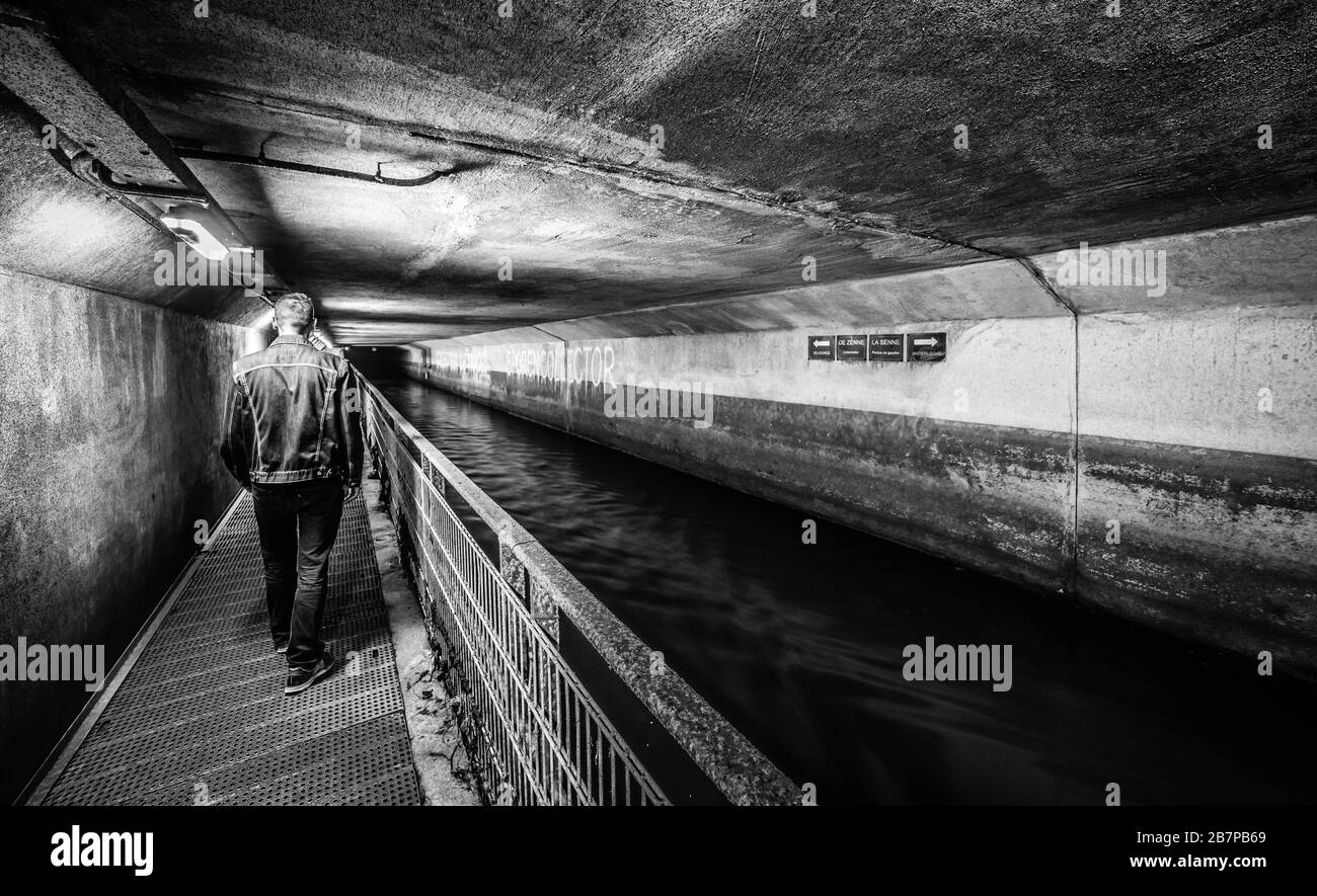 Anderlecht, Bruxelles / Belgique - 07 16 2019: La rivière couverte la Senne, avec un chemin de marche en métal au musée des égouts et une promenade d'homme Banque D'Images