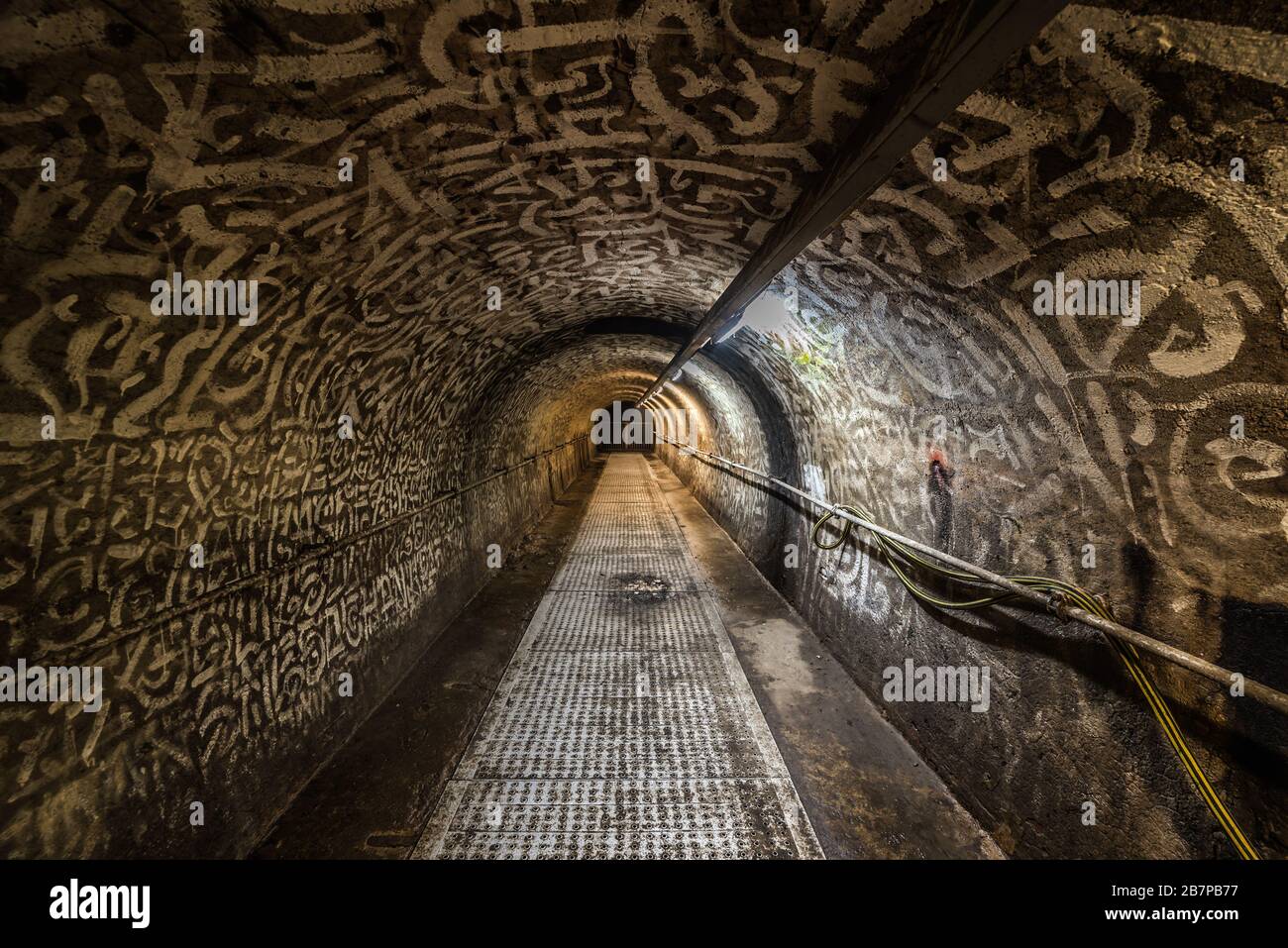 Anderlecht, Bruxelles / Belgique - 07 16 2019: Homme marchant dans les intérieurs industriels du tunnel principal du musée des égouts de la chaussée de Mons Banque D'Images