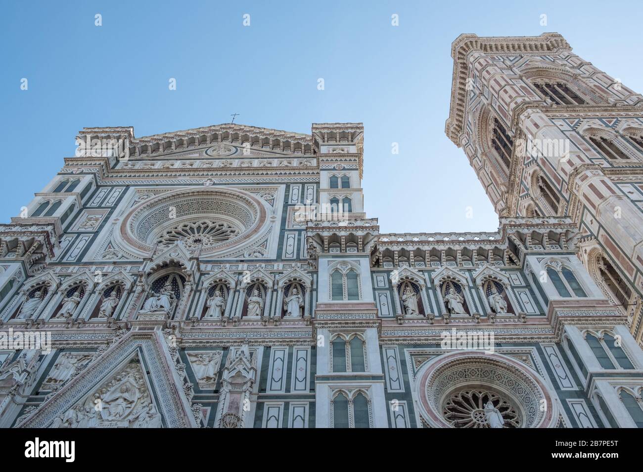 Façade très décorée de la cathédrale de Florence et de la tour Bell, prise de dessous et regardant jusqu'au ciel bleu clair. Banque D'Images