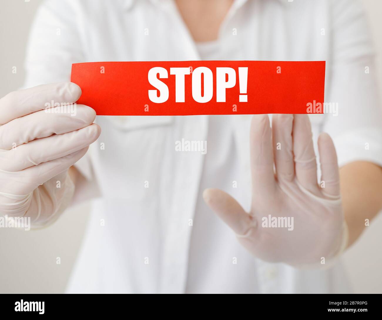 Mise en quarantaine du coronavirus, signe d'avertissement rouge avec texte Stop, le médecin montre un geste d'arrêt des mains pour arrêter l'éclosion du virus corona. Mains de médecin en manteau blanc Banque D'Images