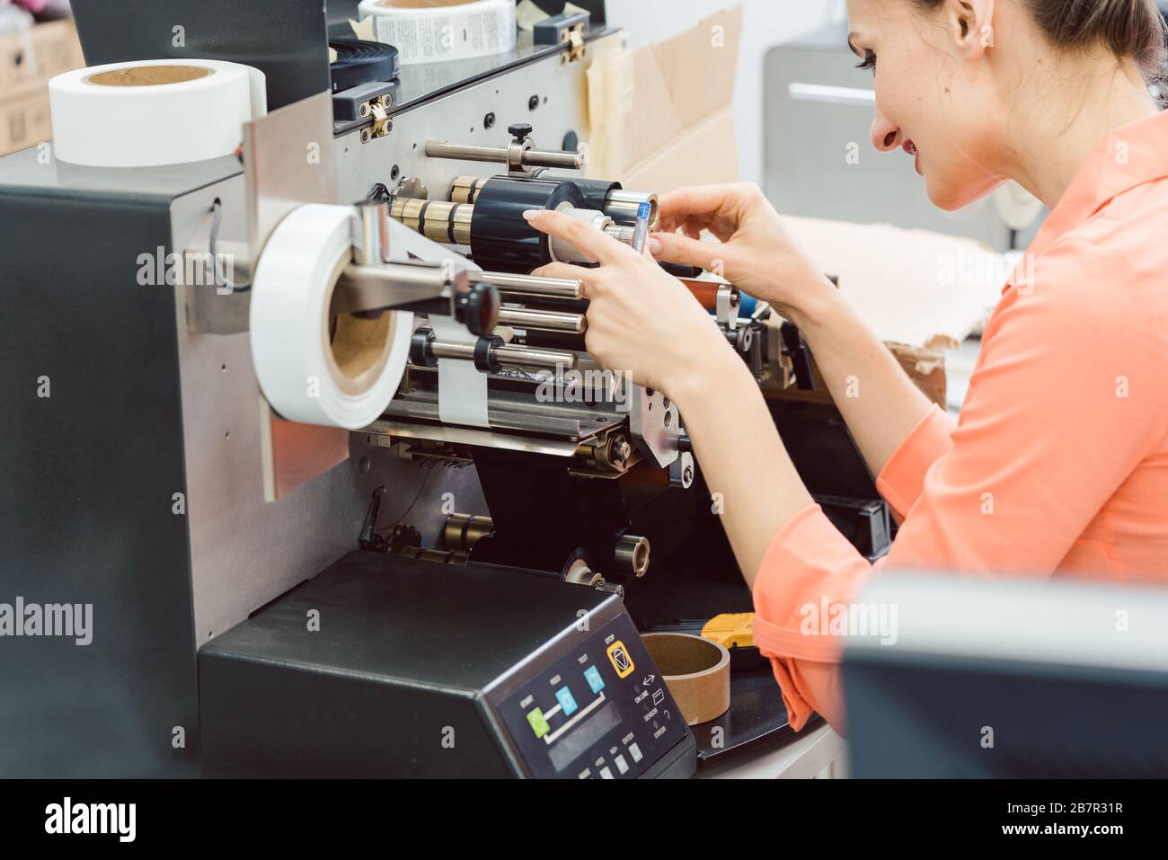Femme travaillant sur une machine d'impression d'étiquettes Banque D'Images
