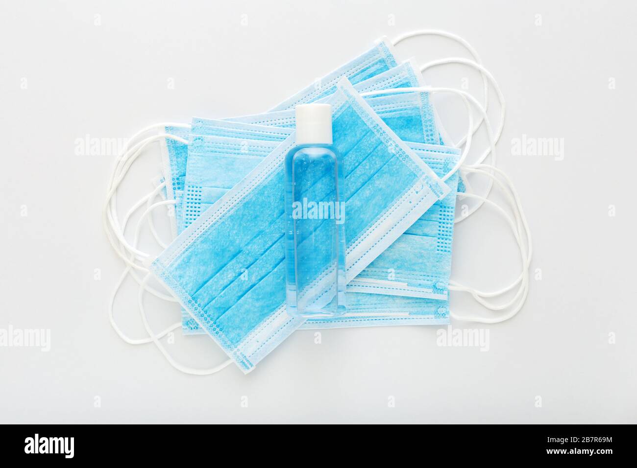 Protection contre le coronavirus. Masques chirurgicaux de protection médicale, gel désinfectant pour les mains sur table blanche. Solution désinfectante antibactérienne pour savon à base de gel d'alcool, mains Banque D'Images