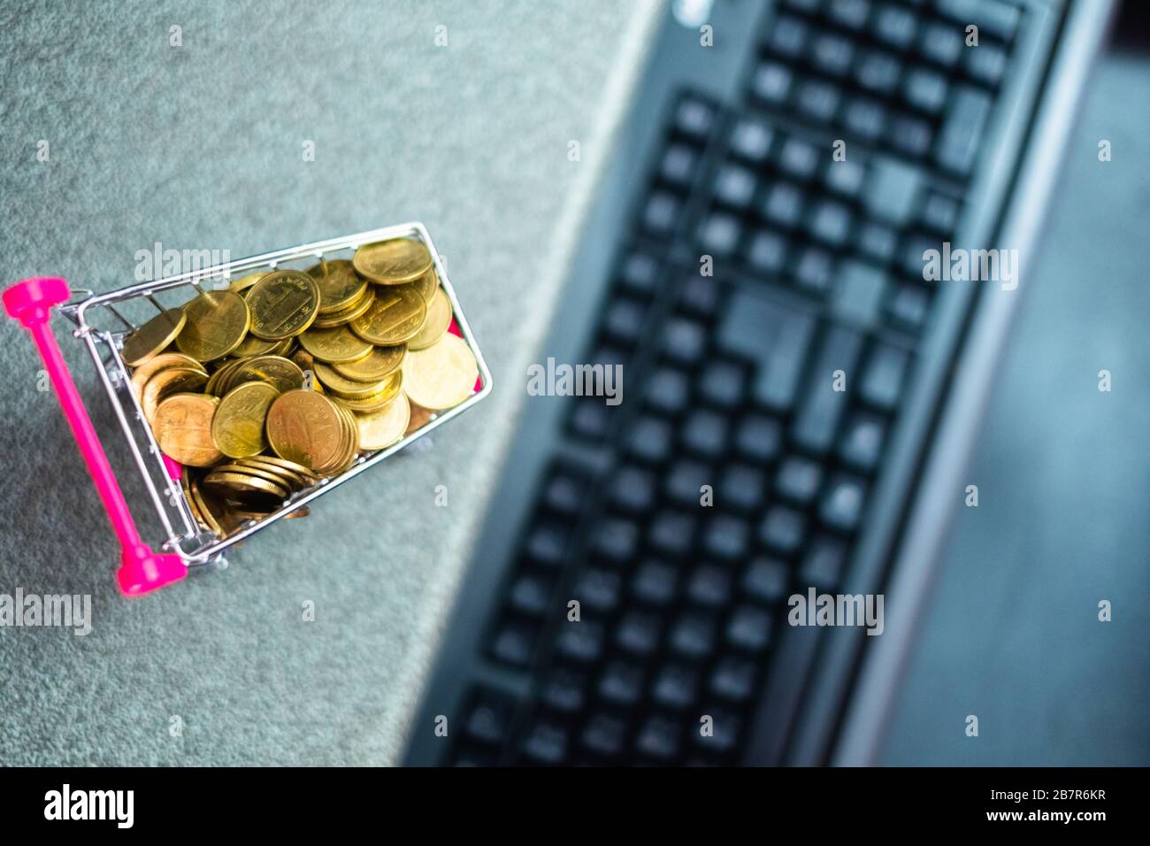 Pièces dans chariot de supermarché chariot avec ordinateur et clavier pour les achats en ligne, e-commerce et concept d'affaires Banque D'Images