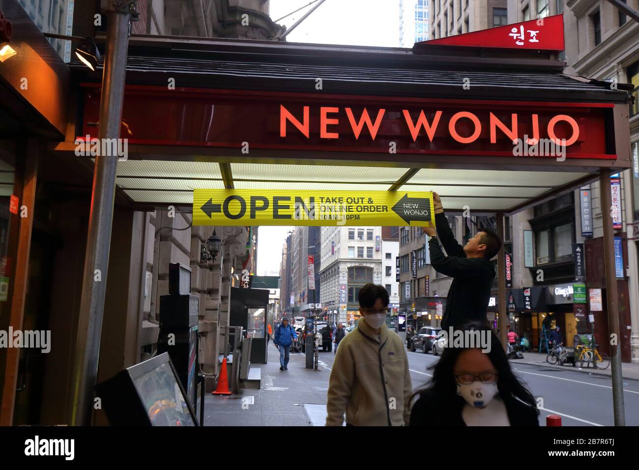 New York, NY, 17 mars 2020. Une personne se tient sur un panneau pour attirer l'attention sur son restaurant de Manhattan est ouvert pour les commandes en ligne et à emporter après qu'un « état d'urgence » d'urgence après une catastrophe a été déclaré au sujet de la pandémie de coronavirus Covid-19. La déclaration limite les bars, restaurants et cafés à servir les repas à emporter et à livrer seulement. Crédit: Robert K. Chin. Banque D'Images New York, NY, 17 mars 2020. Une personne se tient sur un panneau pour attirer l'attention sur son restaurant de Manhattan est ouvert pour les commandes en ligne et à emporter après qu'un « état d'urgence » d'urgence après une catastrophe a été déclaré au sujet de la pandémie de coronavirus Covid-19. La déclaration limite les bars, restaurants et cafés à servir les repas à emporter et à livrer seulement. Crédit: Robert K. Chin. Banque D'Images