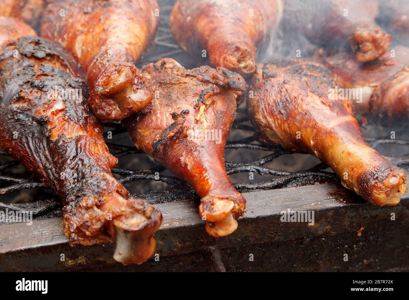 Jambes de poulet sur le gril avec fumée Banque D'Images