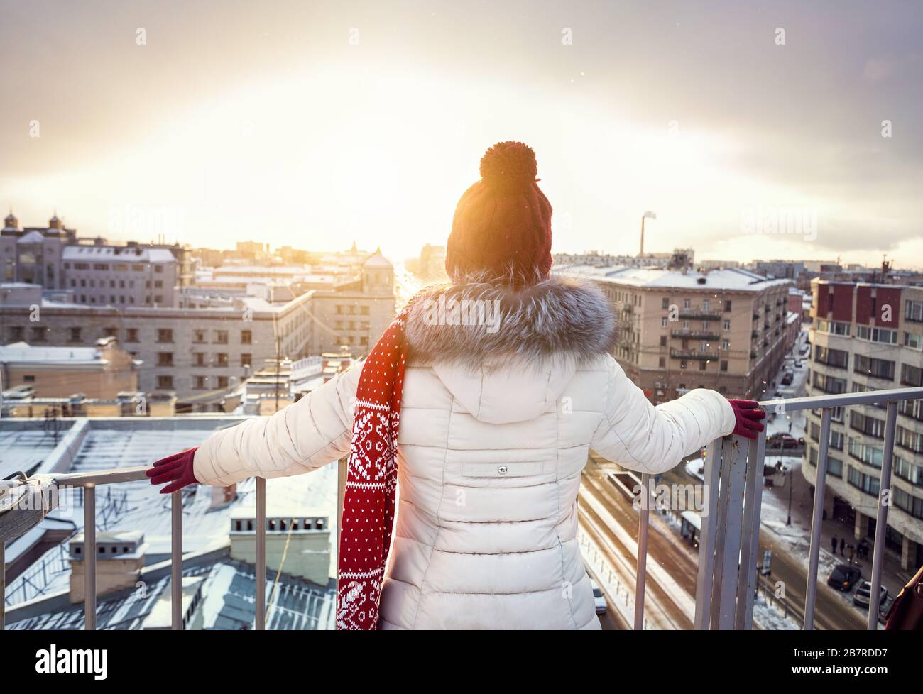 Woman in Christmas Hat et foulard rouge sur le toit à l'automne la neige à Saint-Pétersbourg, Russie Banque D'Images