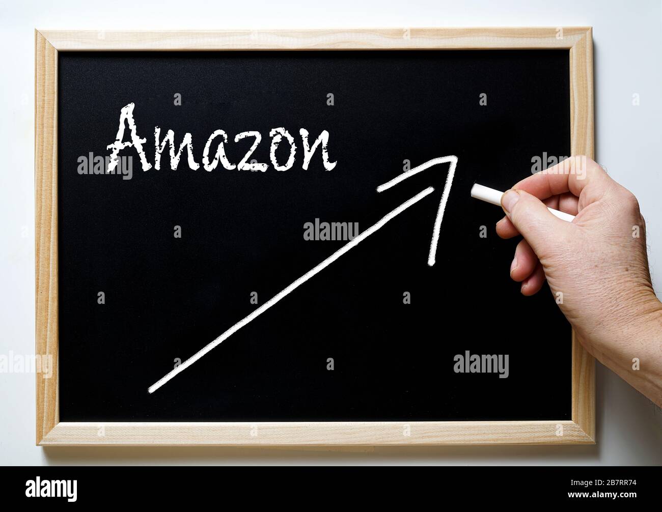 Un tableau noir avec l'écriture de la tendance positive d'Amazon et une  flèche indiquant l'augmentation Photo Stock - Alamy