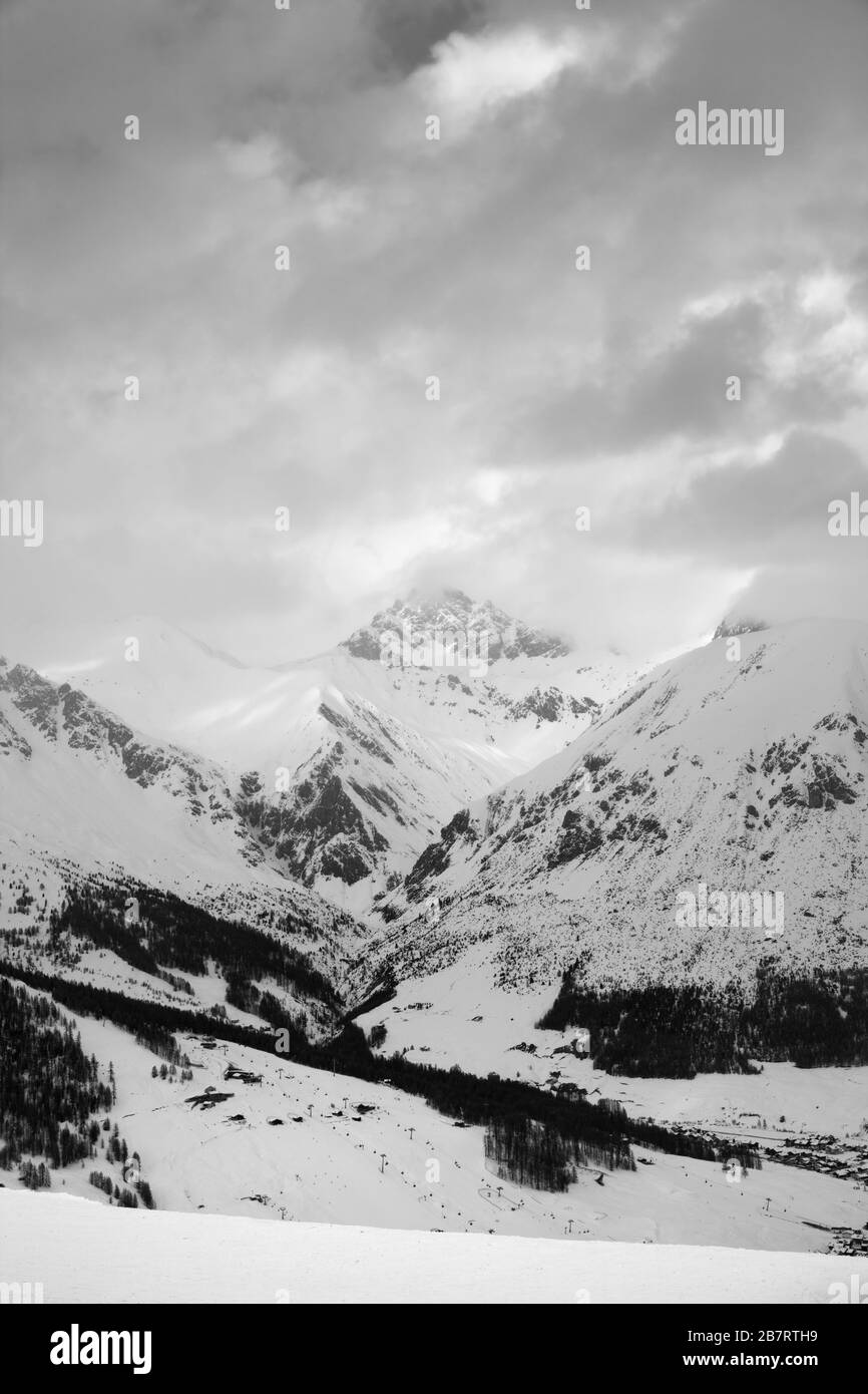 Piste de ski enneigée dans les hautes montagnes et ciel nuageux ensoleillé en hiver soir. Domaine Skiable Mottolino Fun Mountain, Alpes Italiennes. Livigno, Lombardie, Italie, Ue Banque D'Images