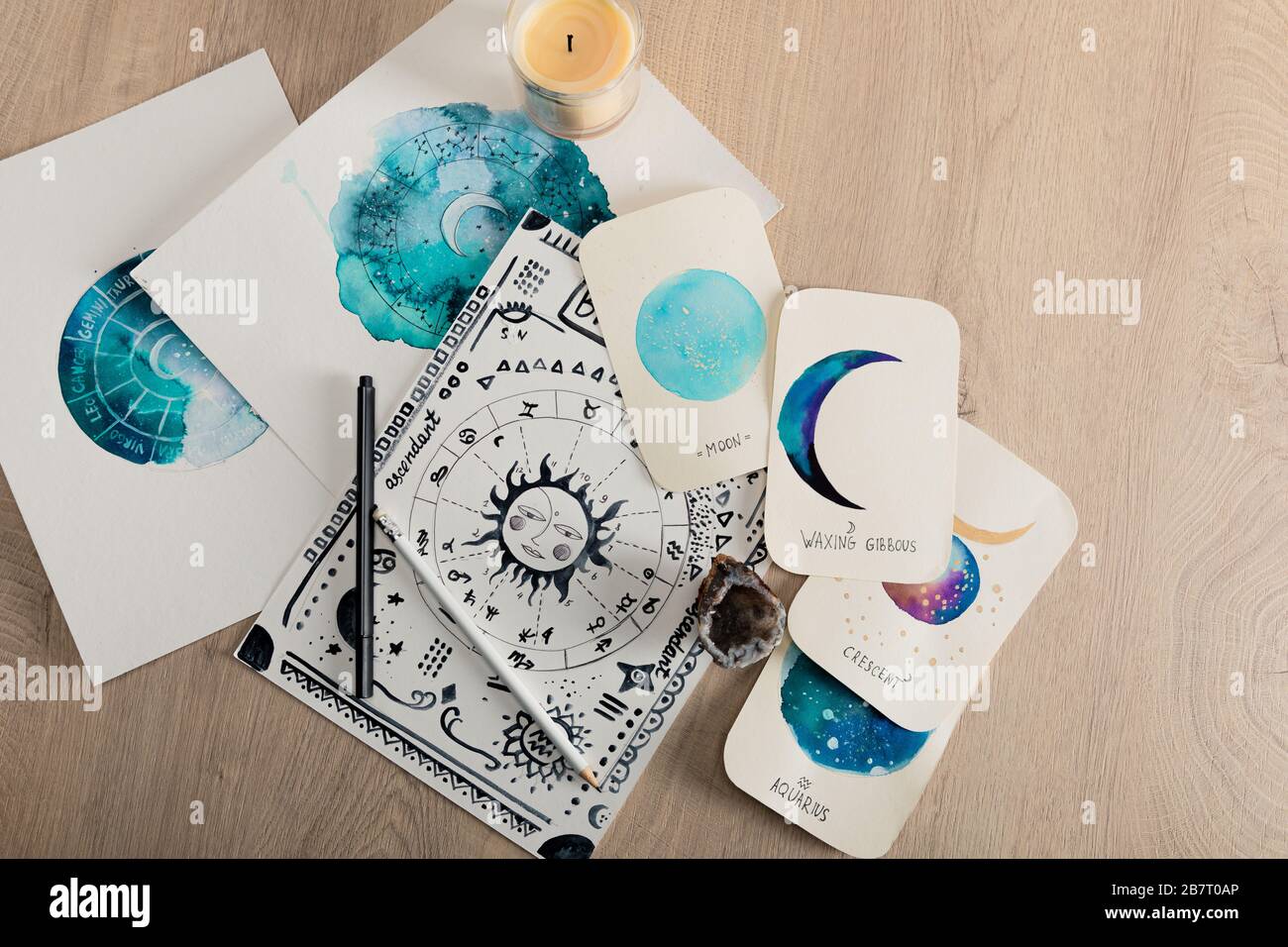 Vue de dessus de la bougie et des cartes avec des dessins aquarelle des phases de lune et des signes de zodiaque sur la table Banque D'Images